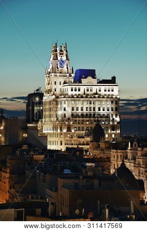 MADRID, SPAIN - MAY 13, 2018: Telefonica Building rise above historical buildings at dusk on Gran Via business district.