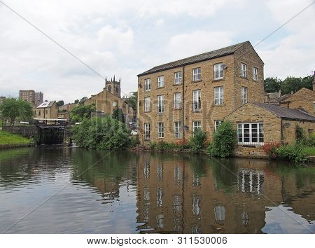 A Scenic View Of The Town Of Sowerby Bridge In West Yorkshire With Buildings Reflected In The Canal 
