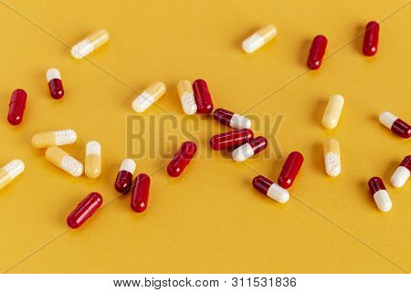 Scattered Yellow And Red Drug Capsules With Active Microgranules