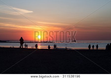 People Walking On The Coast Of The Gulf Of Finland. Spring Evening