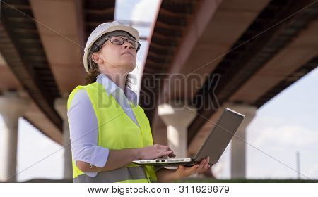 Female Foreman Inspects Object At Building Site. Construction Of Central Ring Car Road.