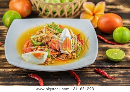 Somtum. Thai Spicy Green Papaya Salad With Salted Egg On Wooden Table.(somtum Khai Kem)