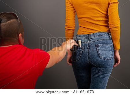 The Thief, Stepping Up Imperceptibly Behind The Girl, Is Trying To Steal A Purse With Dollar Bills F
