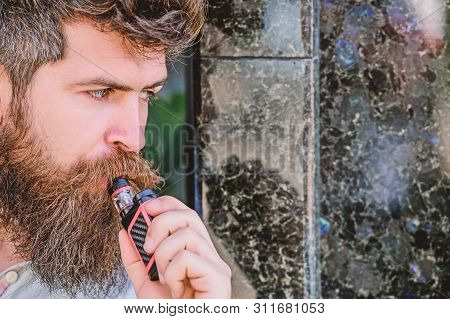 Bearded Man Smoking Vape. Man With Beard Breathe Out Smoke. Smoking Electronic Cigarette. Stress Rel