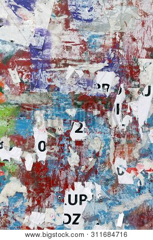 Grungy Flat Wall Surface Covered With Pealed Paper And Red, Green And Blue Spray Paint