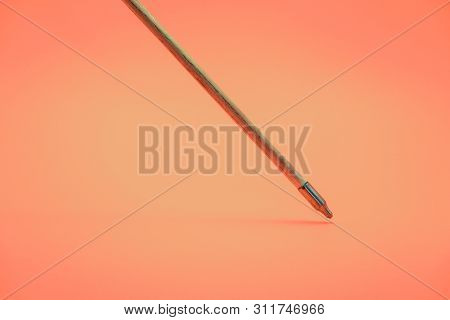Old Green Wooden Arrow On A Beautiful Peach Background.