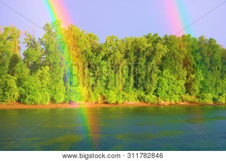 Rainbow After A Rain Storm Above The Willamette River Besides A Temperate Deciduous Forest Taken Nea