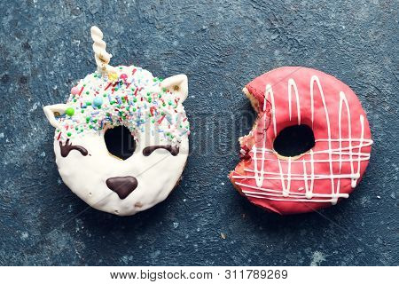 Donuts Over Dark Background. Trendy Doughnut Unicorn With White Glaze And Pink Frosted Donut With Bi