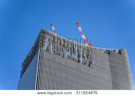 Construction Crane On Top Of Tower Working To Build High Skycrapper Office Building In The Developme