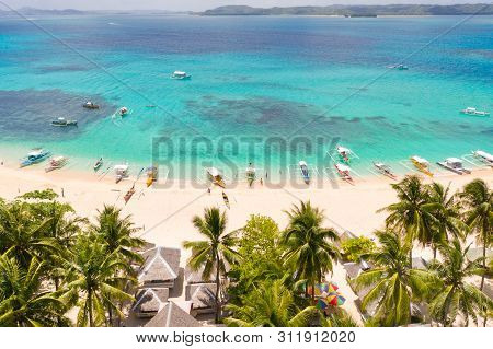 Daco Island, Philippines. Palm Trees And Bungalows On The White Sandy Beach. People Relax On A Tropi