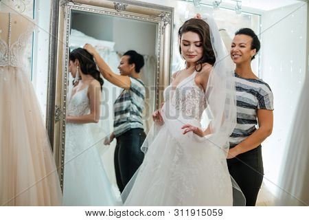 Beautifu bride choosing wedding dress in a wedding salon