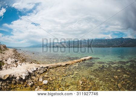 Old Stone Pier On The Adriatic Coast. Sea Coast Of Croatia. Calm Water. Beautiful Places Of European