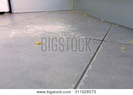Dirty Kitchen Floor With Food Leftovers, Flour, Corn Flakes After Cooking. Close-up View