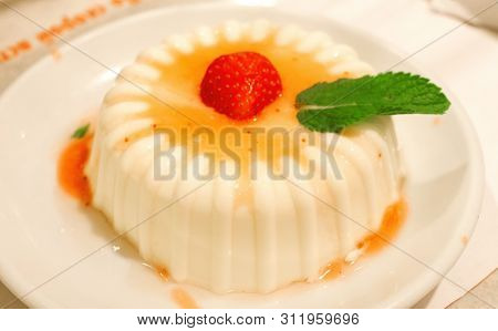 Italian Panakota Dessert On A Plate With Strawberries And Mint Leaf
