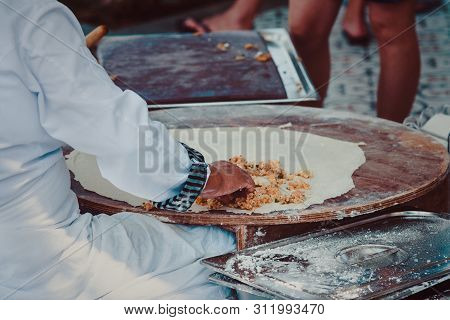 Turkish Woman Prepares Gozleme - Traditional Dish In The Form Of Flatbread Stuffed With Greens And C