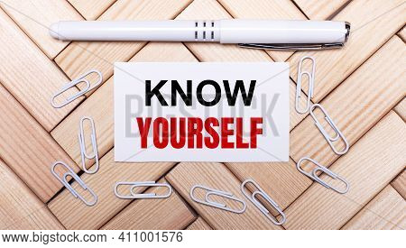 On A Background Of Wooden Blocks, A White Pen, White Paper Clips And A White Card With The Text Kow 