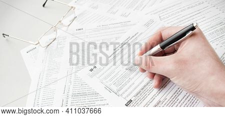 Close Up Of Male Accountant Filling Tax Form. Man Writing Something Sitting At His Office. Filling I