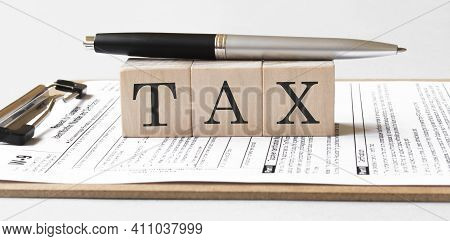 Front View Of Coins And Wooden Cubes With Word Tax. Business Concept.