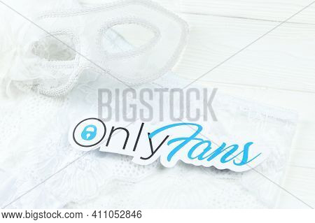 Kharkov, Ukraine - February 14, 2021: Onlyfans Paper Logo And White Lingerie With Carnival Mask On W