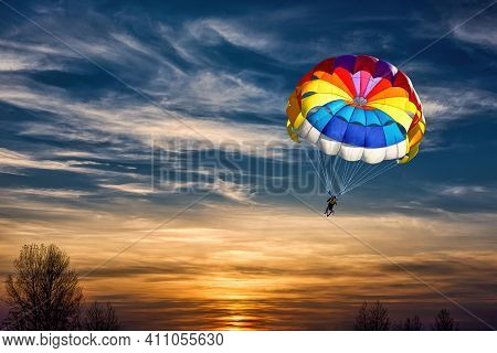 Gliding With A Parachute On The Background Of Bright Sunset.