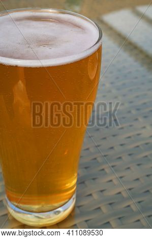 Glass With An Alcoholic Drink, Against The Background Of Bottles With Alcohol. Alcohol Addiction. Ha