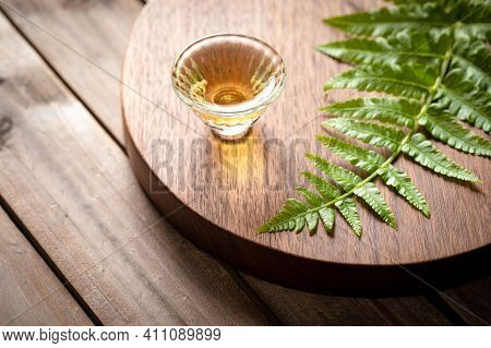 Glass With An Alcoholic Drink, Against The Background Of Bottles With Alcohol. Alcohol Addiction. Ha