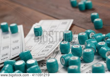 Many Barrels With Numbers And Cards For Lotto Or Russian Bingo Table Game On Wooden Surface. Russian