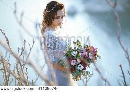 Beautiful Bride In Wedding Dress On The Mountain Top. Stunning Young Bride With Curly Hair And A Bou