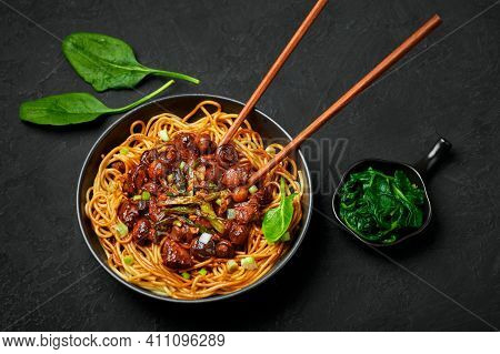 Bakmi Or Mie Ayam In Black Bowl On Dark Slate Table Top. Indonesian Cuisine Noodles Meat Dish. Tradi