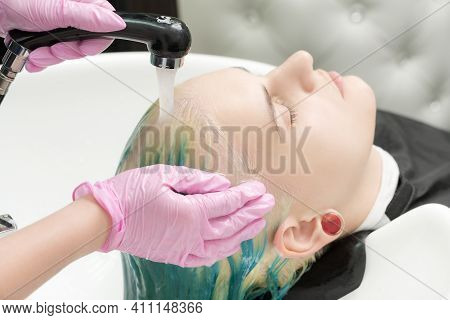 Professional Hair Salon: Hairdresser Washes Clients Head With Green Hair Color. Hairstylist Washing 