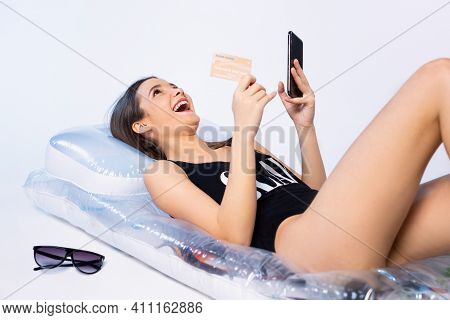 A Happy Girl With A Beautiful Figure In A Cheap Swimsuit Orders Tours By Paying With A Bank Card. Wh