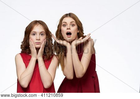 Cheerful Mom And Daughter Next To Red Dresses Hugs Lifestyle Light Background Smile
