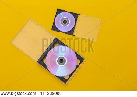 Compact Disсs With Boxes On Yellow Background. Top View