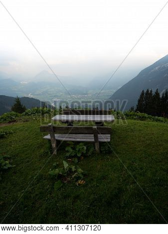 Single Isolated Idyllic Remote Rural Wooden Picnic Table Bench On Green Grass Hill Alpine Mountain O