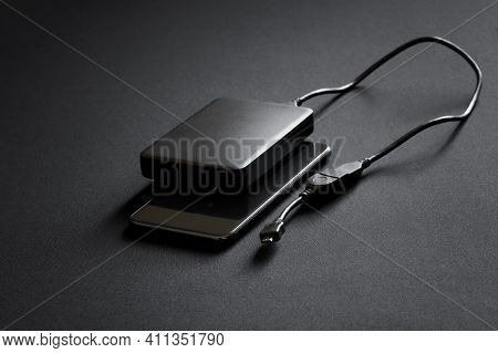 A Black Smartphone And An External Hard Drive With An Otg Cable And An Adapter For Connecting To Gad