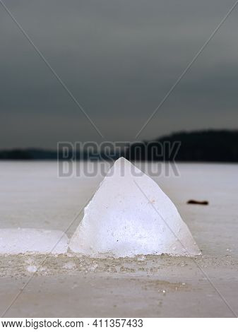 Brightened Piece Of Ice. The Structure Of Radiant Ice Broken Off From The Cover Of The Dam, The Dark