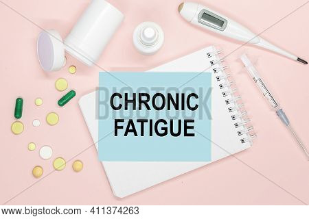 Notebook Page With Text Chronic Fatigue On A Table With Pills And Syringe. Medical Concept.
