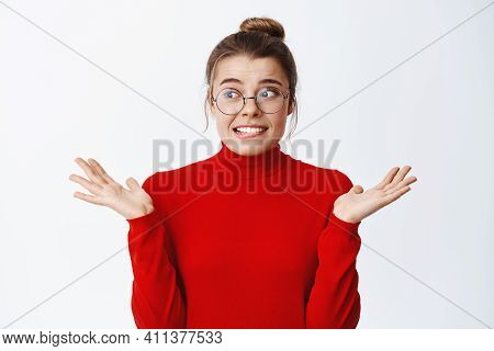 Oops What To I Do Now. Nervous Young Woman In Glasses Worried As Making Mistake, Shrugging And Looki