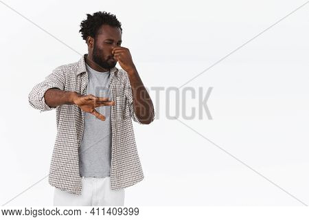 Guy Disgusted From Bad Smell, Step Back And Shield Himself With Hand. African-american Bearded Guy C