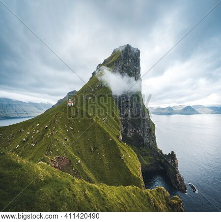 Kalsoy Island With Kallur Lighthouse On On Faroe Islands, Denmark, Europe. Clouds Over High Cliffs, 