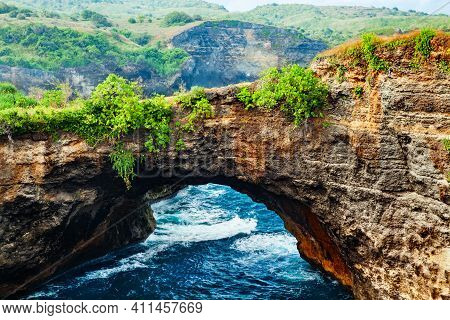 Natural Stone Bridge Over Sea Pool In Broken Bay Beach In Nusa Penida Island. Popular Bali Travel De