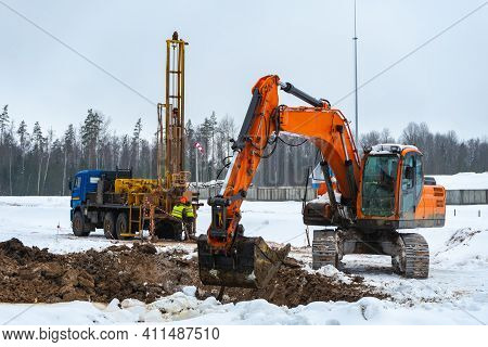 Construction Equipment: Excavator, Drilling Machine, On The Construction Site In Winter. Engineering