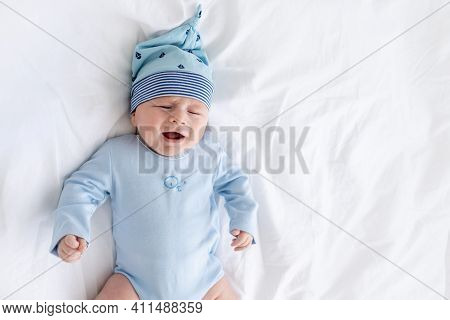 Sad Baby Boy On The Bed Crying Lying On His Back