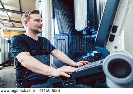 Machine operator programming modern industrial cnc lathe