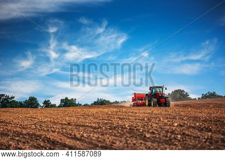 Farmer In Tractor Preparing Farmland With Seedbed For The Next Year