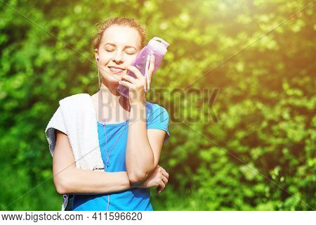 Fitness Woman With Bottle And Towel Of Water After Running Training In Summer Park