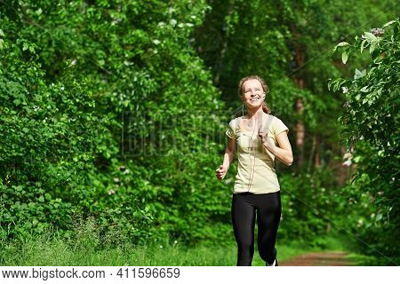 Young Fitness Woman Running At Forest Trail.