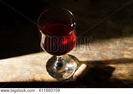 Glass Of Red Homemade Wine On A Wooden Surface. Glass Of Red Wine On A Dark Background. Alcoholic Be
