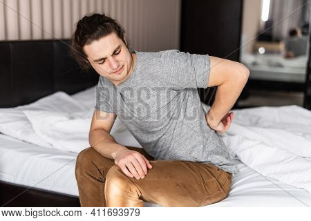 Frustrated Young Man Feels Pain In Back After Sleep