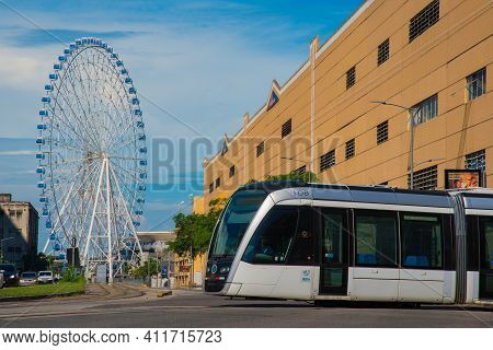 Rio De Janeiro, Brazil - January 7, 2021: Vlt Tram Is Passing In Front Of The Rio Star Ferris Wheel 